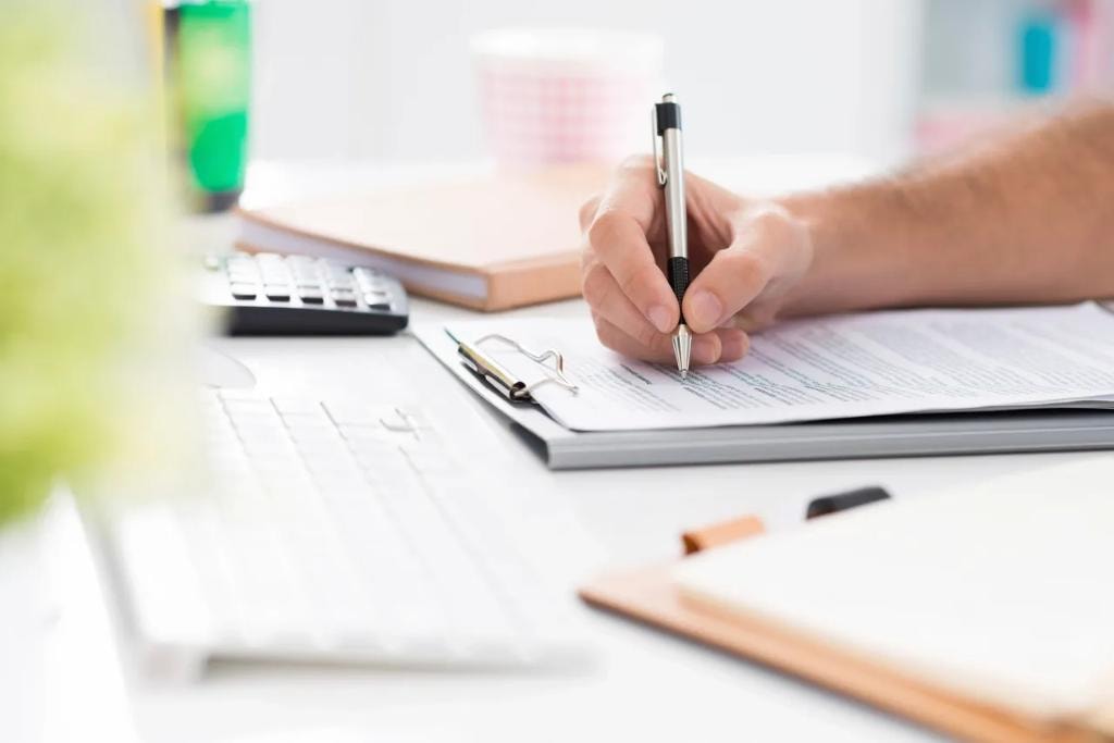 Person writing on tax documents